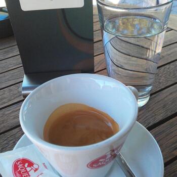 Foto einer Tasse mit Espresso und einem Glas Wasser