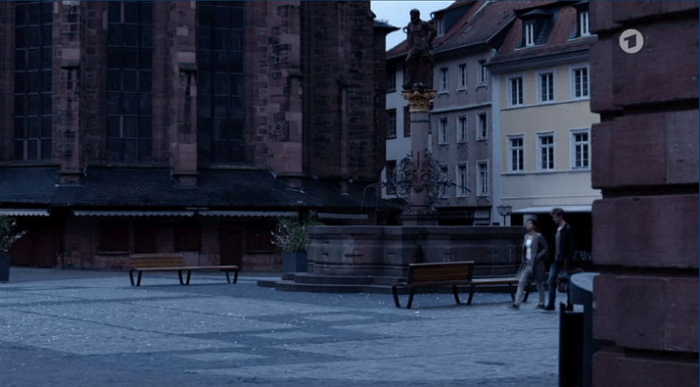 Im Hintergrund ist der Brunnen und die Heiligeistkirche zu sehen.
