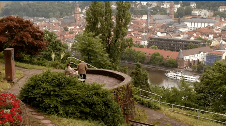 Zwei Personen unterhalten sich mit Blick auf die Heidelberger Altstadt.