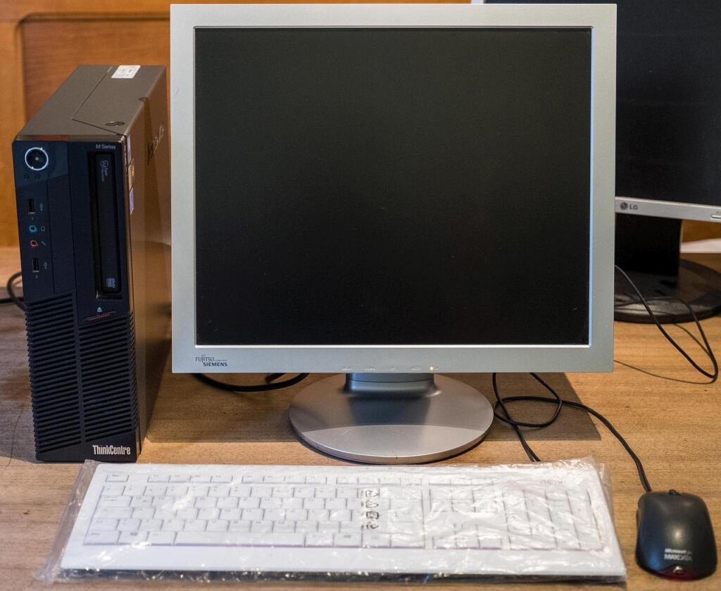 Ein Desktop Computer mit Monitor, Tastatur und Maus auf einem Holztisch