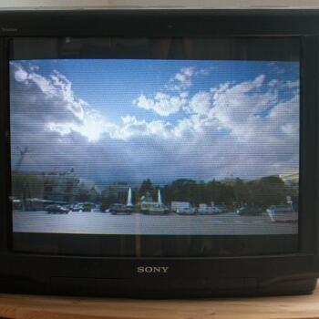 Foto meines schwarzen Sony Fernsehers, der eine Hafenszene mit blauem wolkigem Himmel zeigt