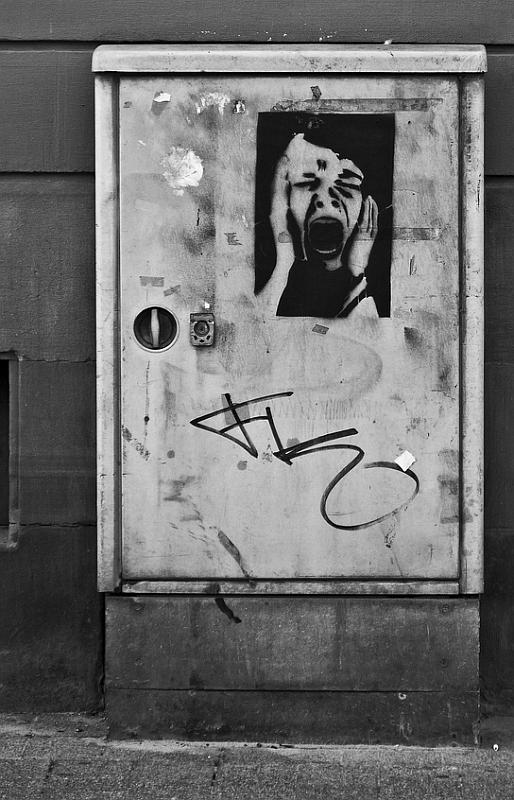 Bild: grauer Stromkasten in der Karlsruher Innenstadt mit Streetart "Scream"