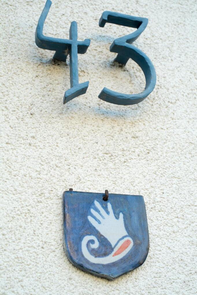 Hausnummer 13 und Handschuh als Wappen am Eingang.