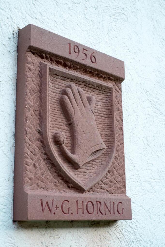 Steinplatte mit Handschuh als Wappen.