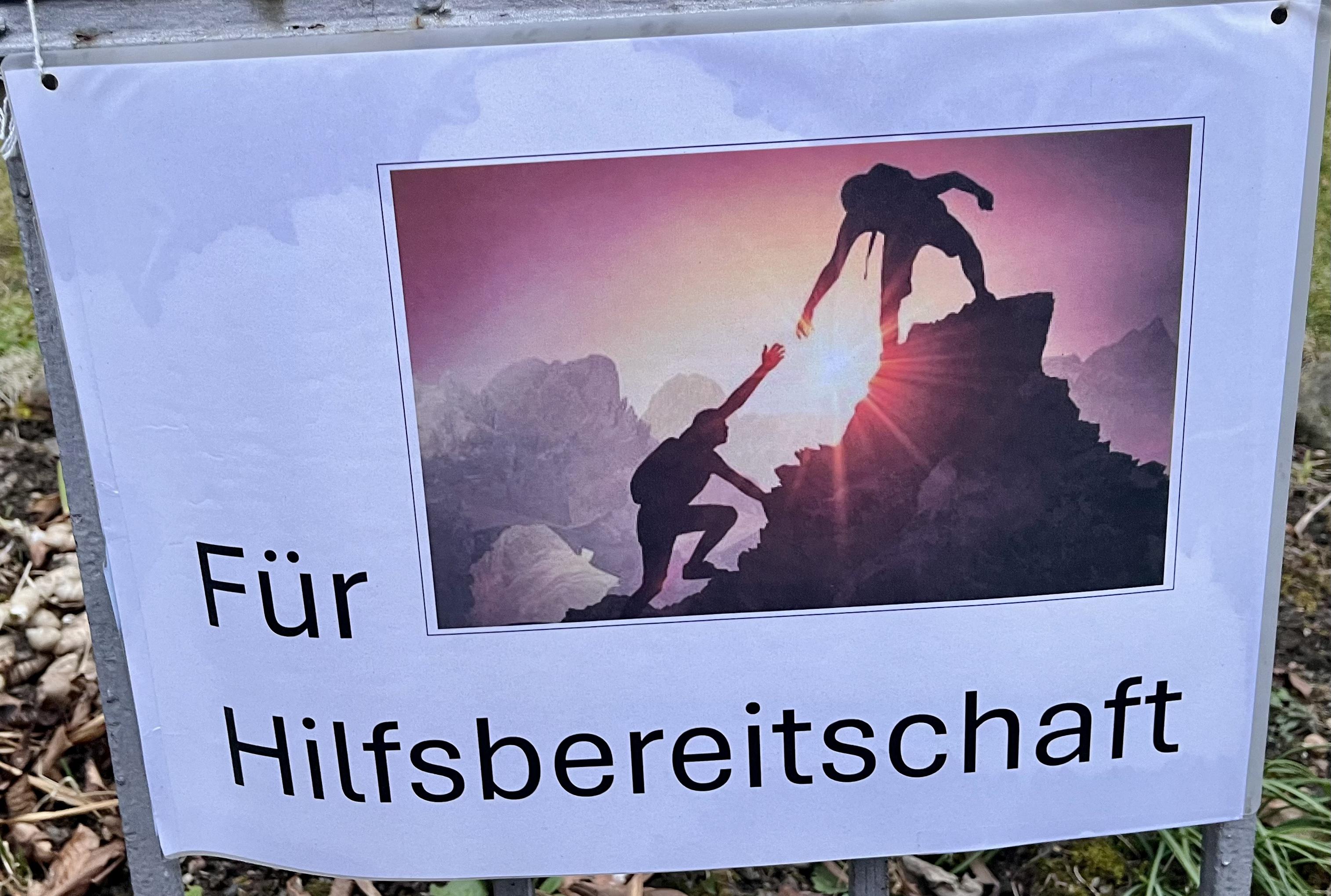 Plakat mit der Aufschrift "Für Hilfsbereitschaft", ein Schmuckbild verdeutlicht diesen Text.
