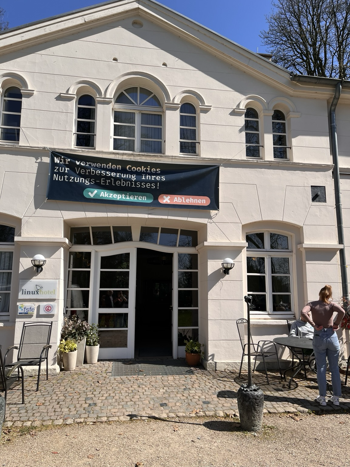 Eingang des linuxhotels, darüber ein Plakat mit der Aufschrift: Wir verwenden Cookies zur Verbesserung ihres Nutzungs-Erlebnisses! Darunter zwei Schaltflächen mit Akzeptieren und Ablehnen. 