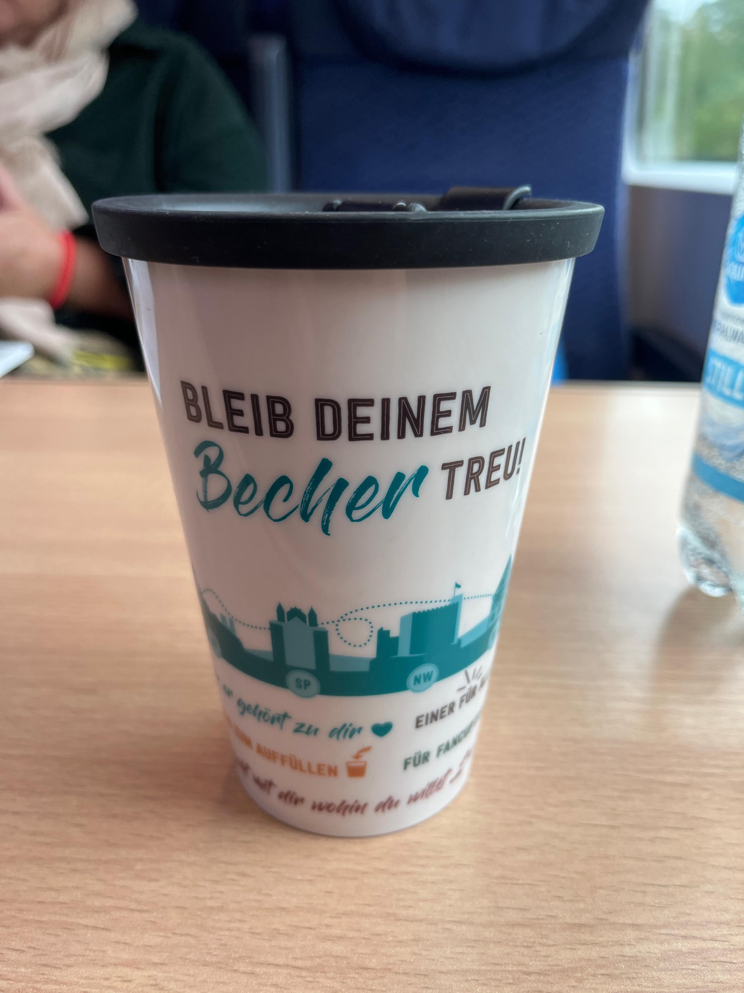 Foto eines Mehrwegbechers. Aufschrift Bleib deinem Becher treu. 
